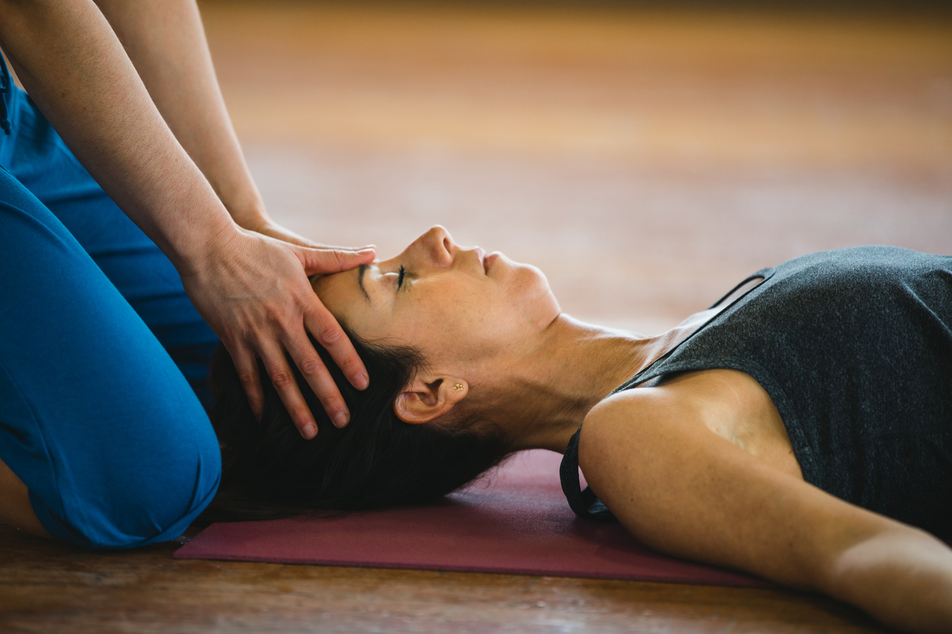 Women practicing yoga position and head massage. Shavasana or Corpse pose